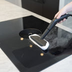 Damprenser med mikrofiberbetræk rengør glaskeramisk kogeplade effektivt uden kemikalier